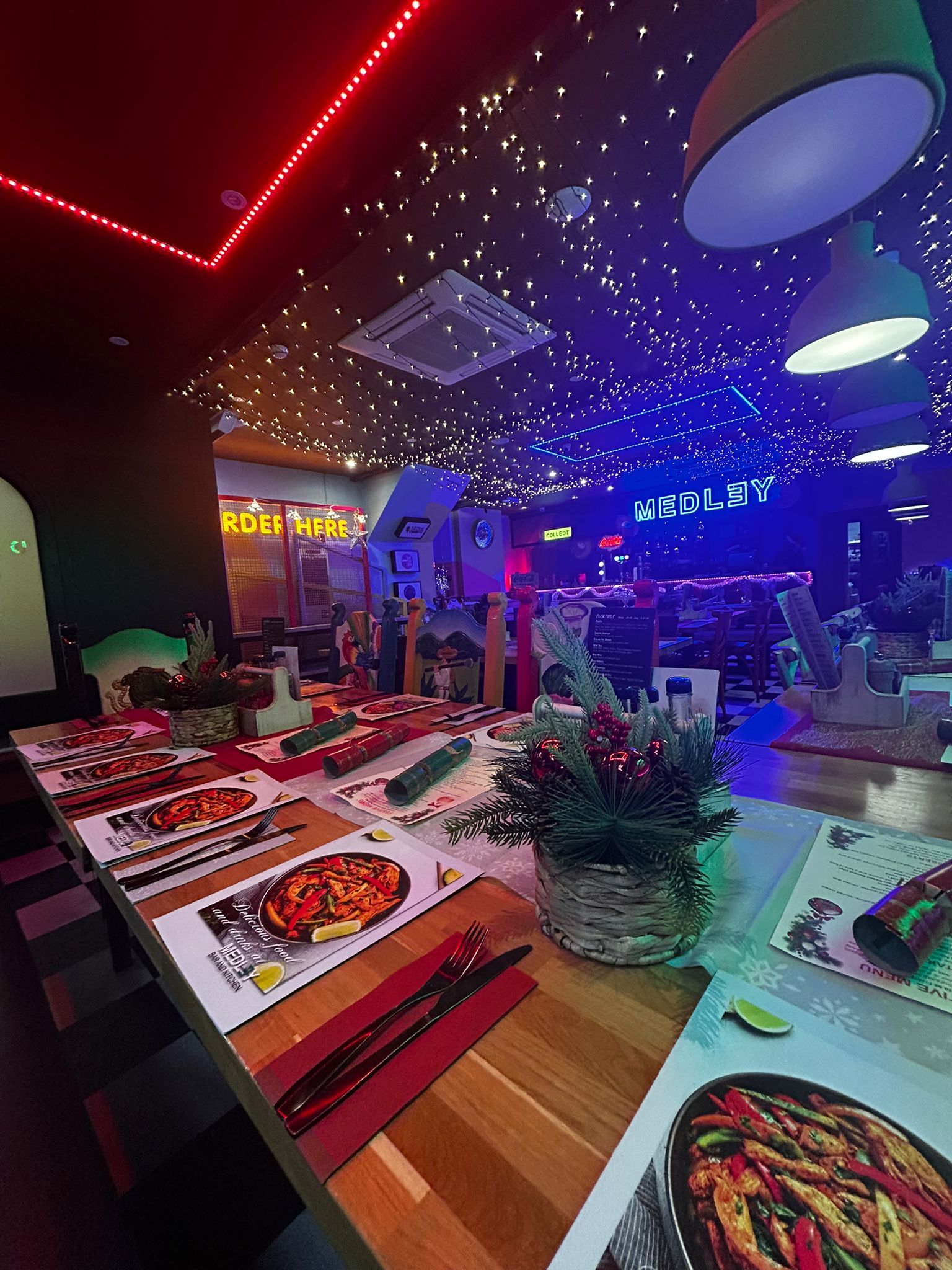 Interior view of Medley Market Mexican restaurant dining area with neon lighting in Orpington