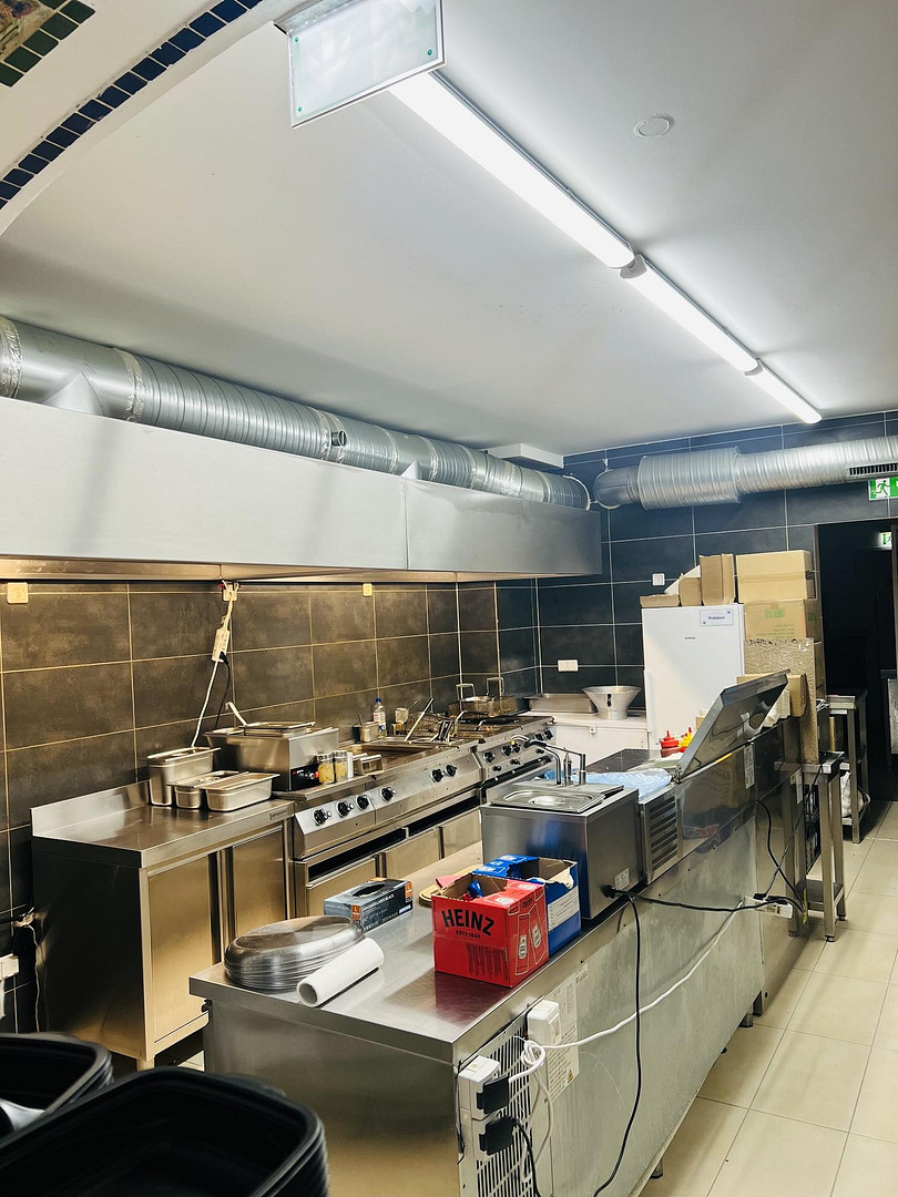 Fully equipped commercial fast food restaurant kitchen with stainless steel counters in Berlin