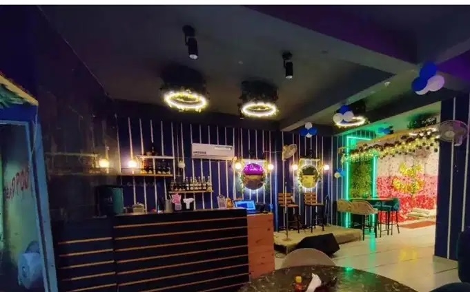 Interior view of modern restaurant and coffee bar dining area with colorful lighting in Kolkata